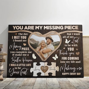 May include: A brown wooden canvas print with a couple's photo in a heart-shaped frame. The text reads "You are my missing piece. The day I met you I found my missing piece. You complete me & make me a better person. I was a little late to be your first. But I want all of my last to be with you. Thank you for coming into my life and making me happy every day." The names "Larry" and "Pamela" are on the bottom of the print.