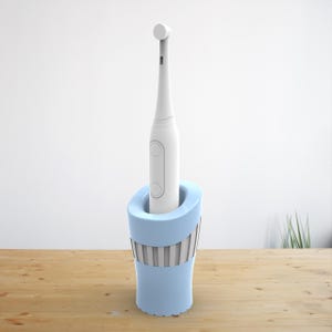 May include: A white electric toothbrush with a blue and white striped charging stand. The toothbrush is standing upright in the stand.