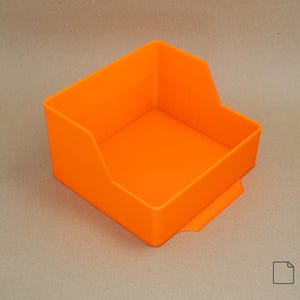 Può includere: Contenitore portaoggetti arancione brillante, con parte superiore aperta, base rettangolare e parte anteriore leggermente curva. Il contenitore ha un piccolo ritaglio a forma di maniglia sulla parte anteriore. Le parole "DIGITAL FILE" e le informazioni sul tipo di file sono nell'angolo in basso a destra.