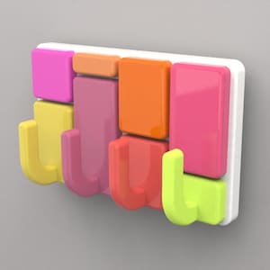 May include: A colourful wall-mounted hook rack with five hooks. The hooks are shaped like the letter J and are in shades of yellow, pink, orange, and green. The rack is made of white plastic.