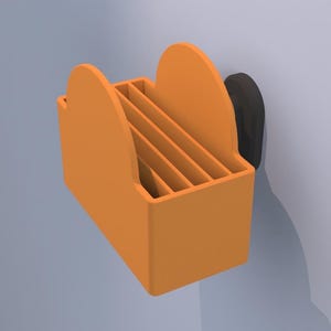 May include: An orange, wall-mounted organizer with a rectangular base and curved top. The organizer has multiple vertical dividers and is attached to a black, circular mounting piece. The design is simple and modern.