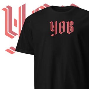 May include: Black t-shirt with a pink and red graphic of the word "YOB" in a bold, geometric font.