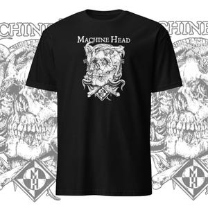 Puede incluir: Camiseta negra con un gráfico blanco de una calavera con cuernos y el texto "MACHINE HEAD" encima.