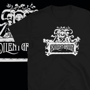 May include: Black t-shirt with a white graphic of a crest featuring two cherubs holding a banner with the text "Soylent Green".