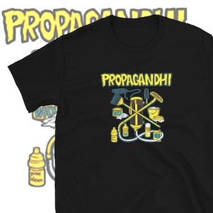 May include: Black t-shirt with a yellow graphic of cleaning supplies and the text "PROPAGANDHI" in yellow.