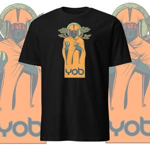 May include: Black t-shirt with a graphic of a person wearing a yellow robe and a crown, surrounded by trees. The text "YOB" is printed in orange below the graphic.