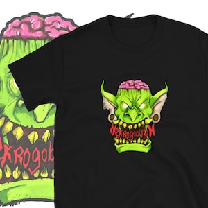May include: Black t-shirt with a green and pink goblin graphic. The goblin has a brain exposed and is wearing earrings. The text "Nekrogoblikon" is written in red below the goblin.