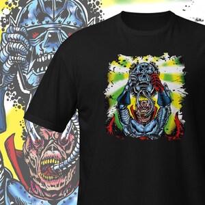 May include: A black t-shirt with a graphic print of a blue and red monster with a helmet. The monster is holding its head in its hands and is surrounded by a yellow and green background.