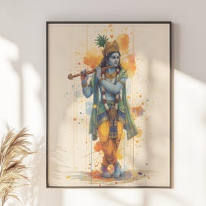 May include: A framed wall art print featuring a blue-skinned figure wearing a golden crown with a peacock feather, playing a wooden flute. The figure wears yellow dhoti trousers, a green shawl, and floral garlands against a watercolour background.