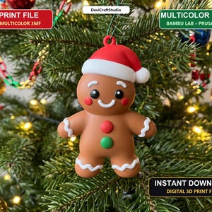 May include: A brown gingerbread person ornament wearing a red and white Santa hat, featuring white icing details on the arms and legs, and two circular red and green buttons on the chest. Text includes 3D PRINT FILE, MULTICOLOR READY, and INSTANT DOWNLOAD.