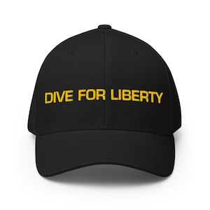 May include: Black baseball cap featuring the embroidered phrase "DIVE FOR LIBERTY" in gold. The cap has a curved peak and a structured design. A classic accessory for everyday wear.