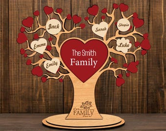Könnte beinhalten: Ein Familienbaum aus Holz mit roten Herzen und Namen auf jedem Zweig. Der Baum ist 3 mm oder 4 mm dick und hat einen Sockel mit dem Text "Unser Familienbaum".