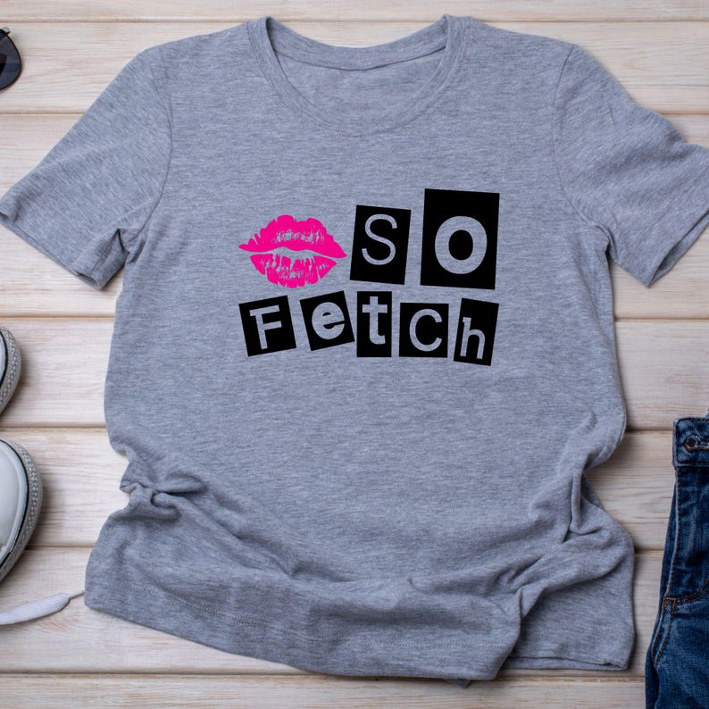 Pu&ograve; includere: Una maglietta grigio melange con un'immagine di labbra rosa e la scritta "So Fetch" in lettere nere. La maglietta &egrave; realizzata in un materiale morbido ed &egrave; adatta per un abbigliamento casual.