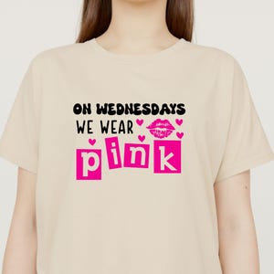 Pu&ograve; includere: T-shirt beige con la scritta "ON WEDNESDAYS WE WEAR PINK" in nero e rosa. Il design include cuori rosa e un paio di labbra. Un capo casual per tutti i giorni.