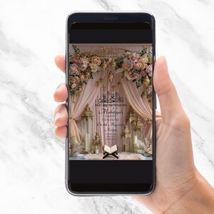 May include: A smartphone screen shows an invitation for Mahdiya's Ameen Ceremony. The design features a floral and lantern backdrop with text in English and Arabic. The invitation has gold accents and soft pink drapes.
