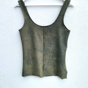 May include: A green sleeveless tank top with a faded, distressed look. The top has a scoop neck and a straight hem.