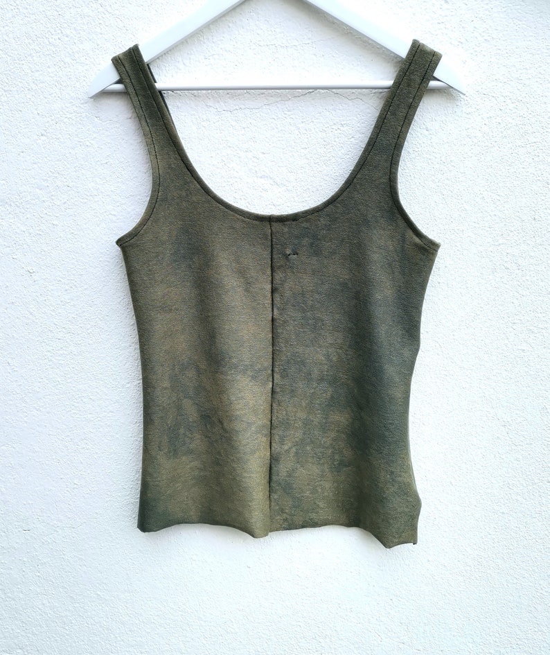 May include: A green sleeveless tank top with a faded, distressed look. The top has a scoop neck and a straight hem.