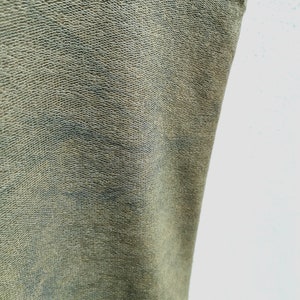 May include: Close-up of a green fabric with a textured surface.
