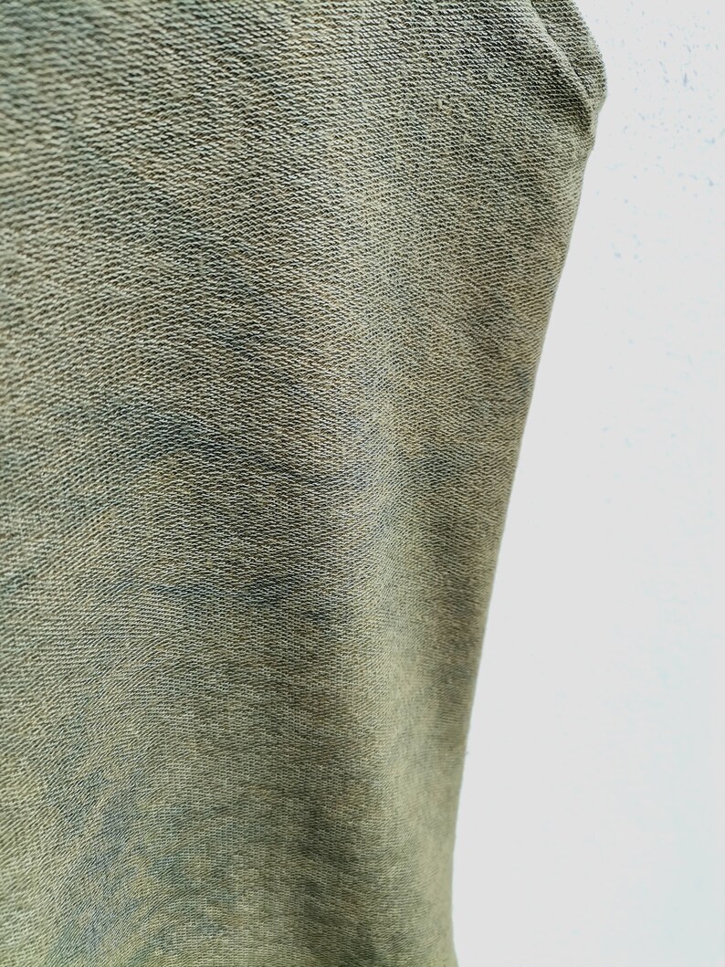 May include: Close-up of a green fabric with a textured surface.
