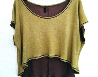 May include: A mustard yellow and brown high-low top with black stitching. The top has a scoop neck and short sleeves.