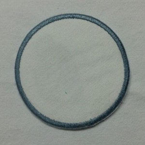 May include: A white, round, blank patch with a blue embroidered border.