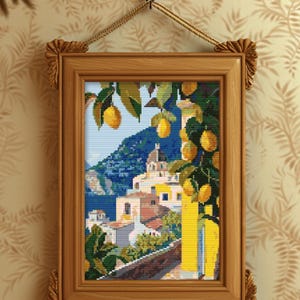 May include: A framed cross-stitch artwork depicting a coastal Italian scene. The artwork features a lemon tree with ripe yellow lemons, a blue sea, and buildings with orange roofs. The frame is made of wood.