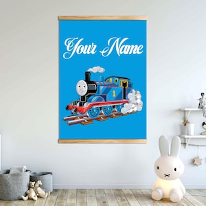 May include: A blue and red cartoon train engine with a smiling face and the number "1" on the side. The train is on a blue background with the text "Your Name" above it.