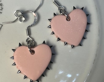 rosa/silverfärgade örhängen med spikar i hjärtat