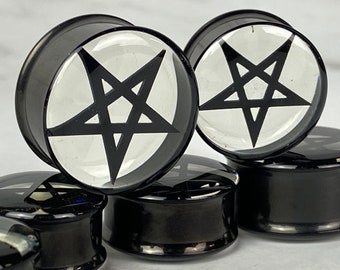 May include: Set of black acrylic ear gauges with a clear pentagram design. The gauges are round and have a smooth, polished finish.