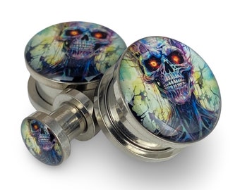 May include: A pair of stainless steel ear gauges with a colorful skull design. The skull has glowing red eyes and is surrounded by a blue and purple aura.