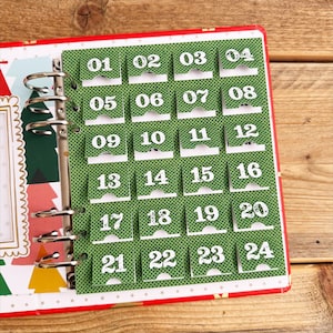 May include: A green advent calendar with 24 numbered flaps, each with a white number. The calendar is made of paper and has a dotted pattern. The numbers are 01 through 24.