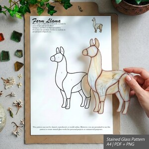 May include: A stained glass llama figure with cream and tan marbled glass pieces joined by copper foil, displayed over a printed A4 paper pattern titled Farm Llama, which features a numbered line drawing of the llama and instructional text.