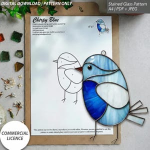 Pode incluir: Um padrão de vitral para um pássaro intitulado Chirky Blue, apresentando um desenho de linha com seções numeradas, uma pequena imagem de referência colorida e um apanhador de sol de vidro azul e branco com linhas de solda de metal escuro.