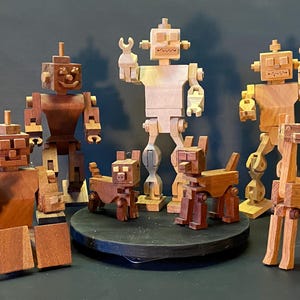 Peut inclure: Une collection de figurines en bois de robots et d'animaux. Les robots sont faits de bois clair et foncé et ont des membres articulés. Les animaux sont faits de bois foncé et ont des designs simples et en blocs. Les figurines sont disposées sur une plateforme en bois.