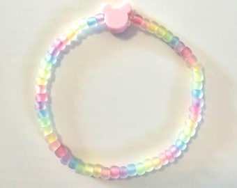 Pulseira de miçangas inspirada no Mickey - Arco-íris que brilha no escuro com miçanga rosa como detalhe principal.