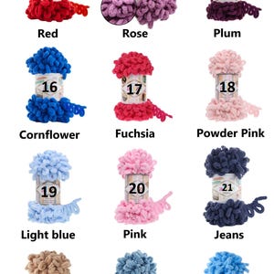 May include: A collection of colorful yarn skeins in various shades, including red, rose, plum, cornflower, fuchsia, powder pink, light blue, pink, jeans, beige, dusk blue, and blue. Each skein is labeled with a number and color name.