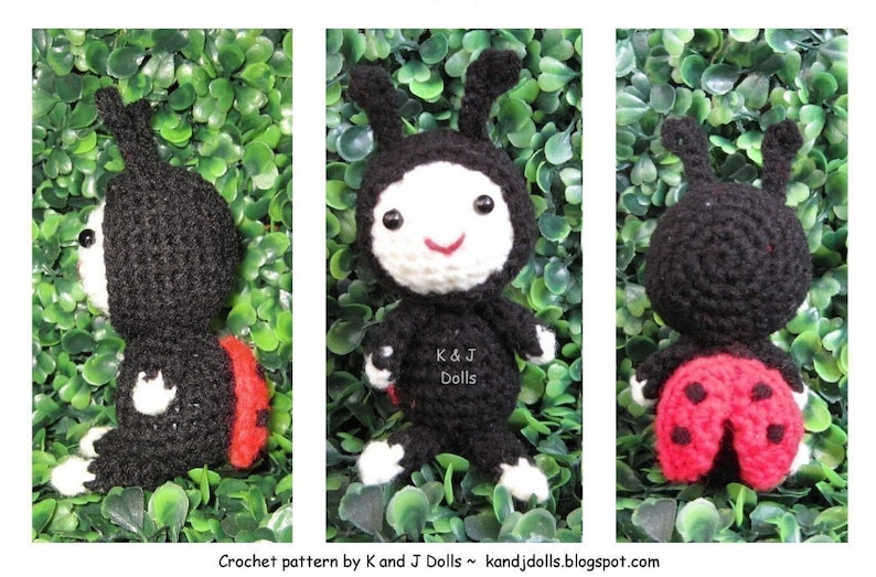 May include: Crocheted ladybug doll with a black body, red and black wings, and white face and feet. The doll has a smiling face and small antennae. The text "K & J Dolls" is visible on the doll's body. The background is green.