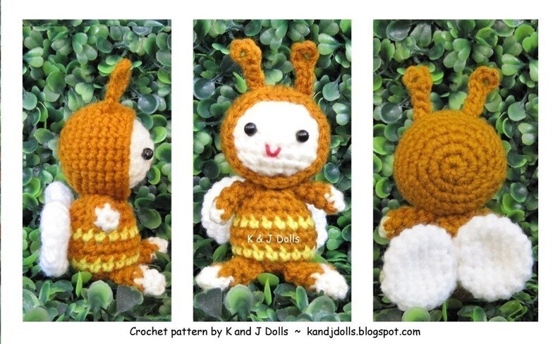 May include: A handmade crochet doll in three views. The doll has a brown head and body with white accents, including the face, wings, and feet. The doll is sitting in front of a green leafy background. The text "K & J Dolls" and a website address are visible.