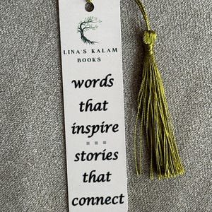 Op de afbeelding: Een witte bladwijzer met een groen boomlogo en de tekst "Lina's Kalam Books" en "words that inspire stories that connect". De bladwijzer heeft een groene kwast.