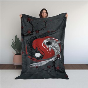 Könnte beinhalten: Ein schwarz-weißes Yin-Yang-Design mit zwei Koi-Fischen, die um einen roten Kreis schwimmen. Die Fische sind von einem grauen Hintergrund mit roten Kirschblüten umgeben.