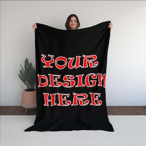 Puede incluir: Manta de forro polar negra con el texto "YOUR DESIGN HERE" en rojo.