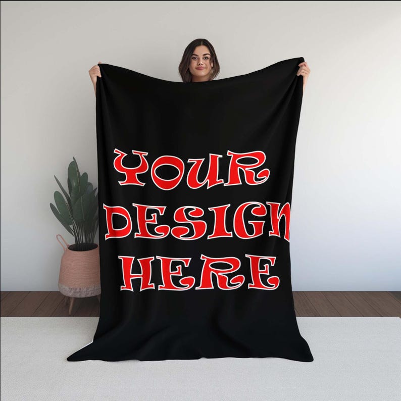 Puede incluir: Manta de forro polar negra con el texto "YOUR DESIGN HERE" en rojo.
