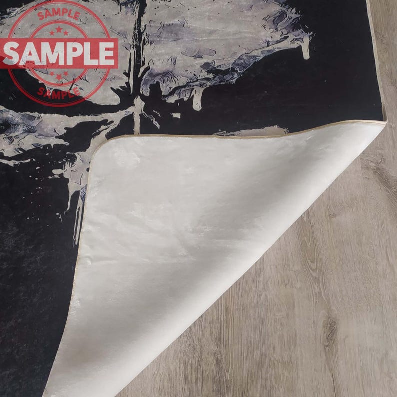 Puede incluir: Una alfombra de arte abstracto en blanco y negro con un respaldo blanco. La alfombra tiene un aspecto desgastado y est&aacute; hecha de un material suave y mullido.