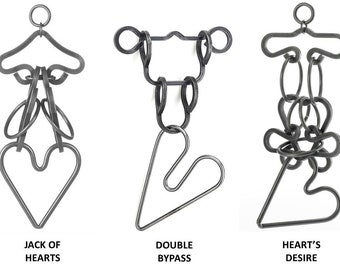 Può includere: Quattro puzzle in metallo a forma di cuore, ognuno con un design diverso. I puzzle si chiamano "Iron Heart", "Jack of Hearts", "Double Bypass" e "Heart's Desire".