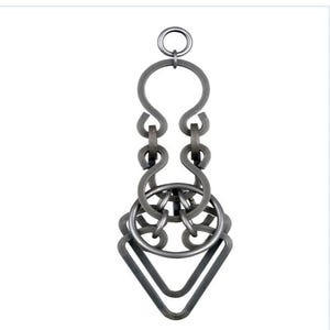 May include: A silver-colored metal puzzle with a complex, interlocking design. The puzzle features a ring at the top, connected to a series of curved and looped metal pieces, culminating in a triangular shape at the bottom. The intricate design suggests a brain teaser or decorative item.
