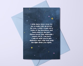Può includere: Un biglietto di auguri con sfondo blu scuro e busta azzurra. Il biglietto presenta un disegno stellato con stelle gialle e rosa. Il testo sul biglietto recita: "Vorrei che ci fosse un modo per rendere tutto questo migliore per te..."