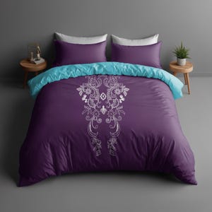 Puede incluir: Funda nórdica morada con un diseño floral blanco y una almohada de acento turquesa.