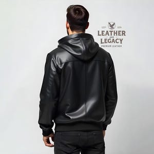 May include: A black leather jacket with a zipper closure and a hood. The jacket has a logo on the back that says "Leather and Legacy, Premium Leather".