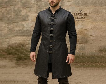 May include: A black leather vest with multiple buckle closures and a matching belt. The vest is worn over a long-sleeved black shirt. The image includes the text "Leather and Legacy Premium Leather".
