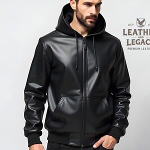 May include: A black leather jacket with a zipper closure and a hood. The jacket has a logo on the back that says "Leather and Legacy - Premium Leather".